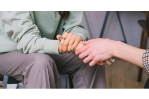 Person holding the hand of another and demonstrating a gesture of sympathy.