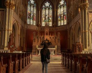 Woman standing in the aisle of Catholic Church.
