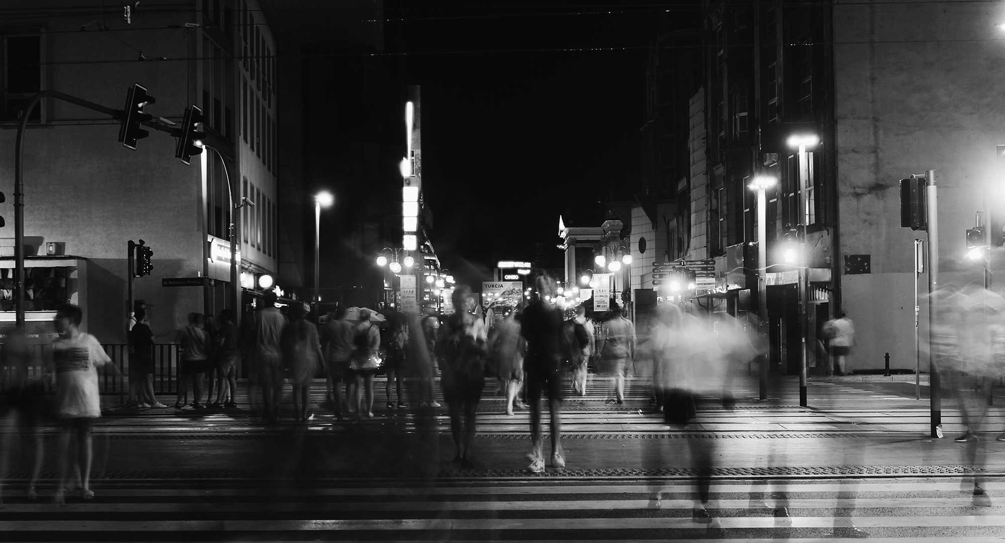 Bluer of people walking in the city at night.