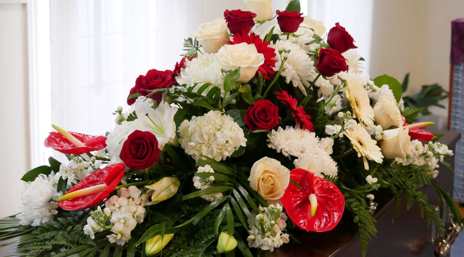 Large funeral flower arrangement with roses.