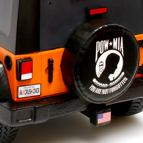 The back of the 3D-printed Jeep features a realistic license plate that reads "CRUSH CNCR" and a spare tire cover with the American POW and MIA flag.