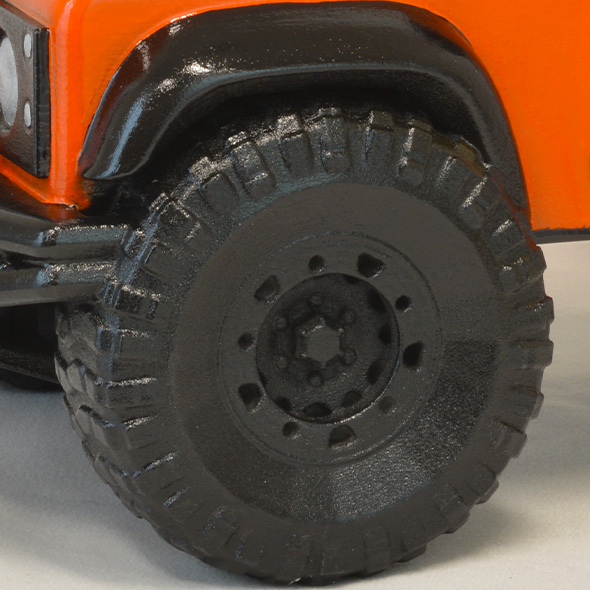 A close-up of the black tires on the 3D-printed Land Rover custom urn.